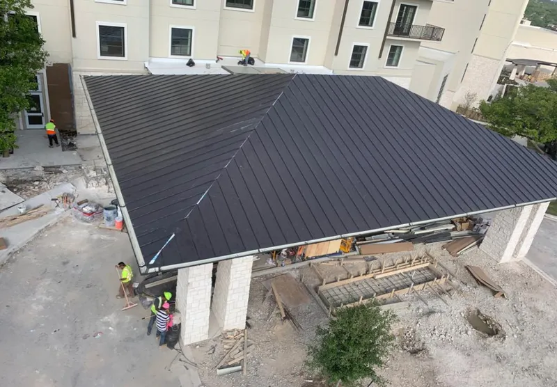 Metal roofing installation team working on a commercial building in Greenville